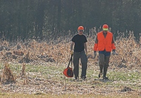 The bird planting team walks out of the Junior field. The left-hand planter is carrying the bird bag.