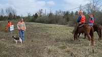 A pair of handlers on the line for a senior test get some last minute course review tips from the judges that will watch their brace of dogs.