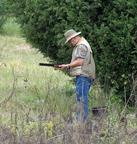 There's a fair amount of waiting involved. The damp sky is keeping the doves from moving. This hunter stands up from his seat-bucket to stretch his legs and make sure his over-under is ready for a flyover.