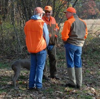 Two handlers and a between-braces gunner do the most important thing that happens at a hunt test: learn a few things from each other.