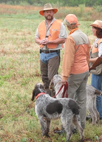 A judge reviews the course with two handlers on the lineâ€¦