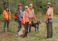 Judges, handlers, and a brace of Junior Hunter dogs watch for the field to clear before heading out.