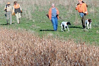 Handlers and gunners chat on their way out of the field after the judges call time's-up.